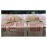 Red and white striped blanket with two pillows,