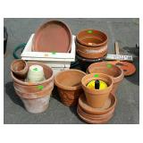 Group of terracotta flower pots and plastic flower