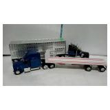 Two toy tractor trailer trucks one flatbed, one