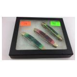 Display case with three pocket knives
