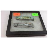 Display case with two pocket knives fishing and