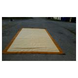 Wool room rug, with tan center and orange trim,