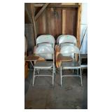 Six metal folding chairs with attached desktops.