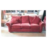 Three cushion sofa with two throw pillows, burnt