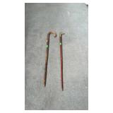 Two walking canes, one does have a duck head on