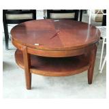 Drum style coffee table with under shelf. Shows