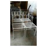 Set of four wrought iron patio chairs.