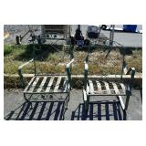 Two green painted metal patio chairs, one does