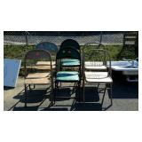 Stack of six metal folding chairs