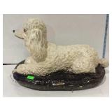 Poodle Dog Figure laying on black pet pillow all
