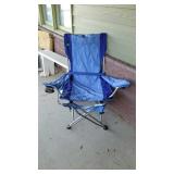 Folding camping chair with foot rest, located on