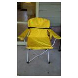 Yellow folding camping chair, with bag located on