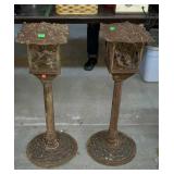 Two cast iron candle holders, the door on one