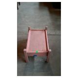Stand, looks like a doll bed frame pinkish in
