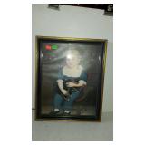 Framed wall print of girl in chair with pet dog,