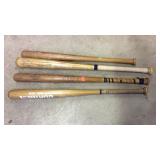 Four wooden Ball Bats and 2 softballs in a bucket