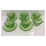 Five green glass tea cups and saucers, one extra