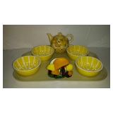 Four yellow grapefruit bowls with teapot and