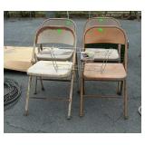 Four folding metal chairs all show weathered use
