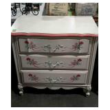 Three drawer dresser with painted floral ribbon