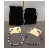 Two beaded necklaces with velvet bags
