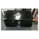 Black storage trunk on wheels, measures 31 inches
