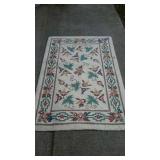White room rug with flower design and border