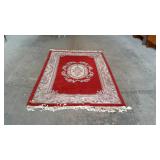 Red wool oriental rug with flower border and