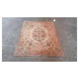 Wool pink area rug with flower center measures 68