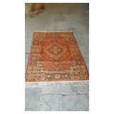 Wool oriental orange rug, measures 84 inches long
