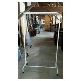 White metal clothes rack with top bar for storage