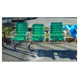Three lawn chairs, 2 are straight and one is a