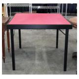 Wooden folding card table with red felt top,
