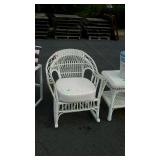 Old wicker rocking chair with cushions has wear