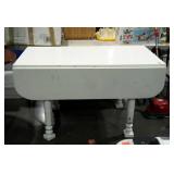 Drop leaf table with chippy white paint and turned