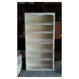 Tall wooden bookshelf, four of the shelves are