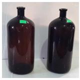 Brown glass bottles, one still has a cork in it,