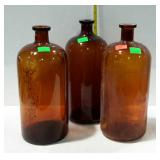 Three brown glass apothecary bottles - 14" tall