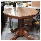 Oak pedestal table, 36" across, dark finish, has