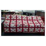 Red and white patchwork quilt. Edges worn.