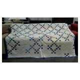 White, blue and grey patchwork quilt. Some wear