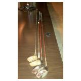 Four vintage golf clubs.