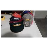 Various college football hats and visors