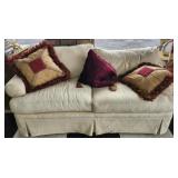 Beige color couch with red pillows