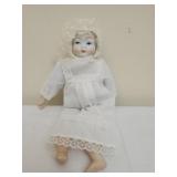 Vintage porcelain baby doll in white dress