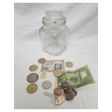 Old coins & banknotes displayed in glass jar