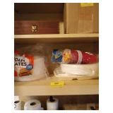 Shelf of foam plates, solo cups, plastic trays