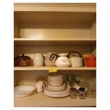 Two shelves full of kitchen items, mostly plates