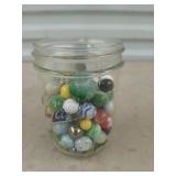 Ball jar of assorted shooters and marbles