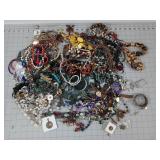 Plastic tub of lots of beaded jewelry and other